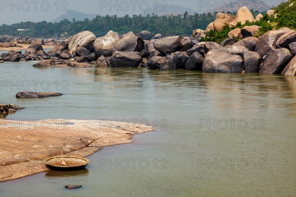 Traditional wickerwork coracle boat in Hampi on bank of Tungabhadra river