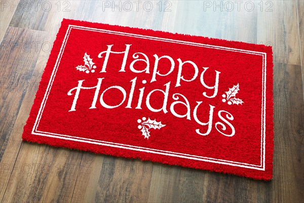 Happy holidays christmas red welcome mat on wood floor background