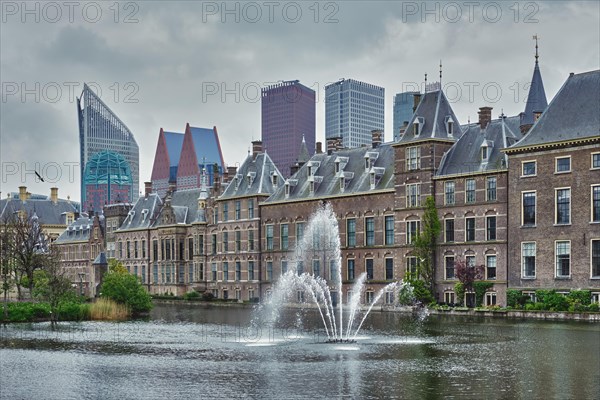 View of the Binnenhof House of Parliament and the Hofvijver lake with downtown skyscrapers in background. The Hague