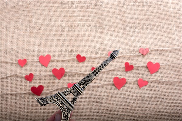 Love concept with Eiffel tower and paper heart on threads