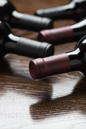 Various wine bottles on a reflective wood surface abstract