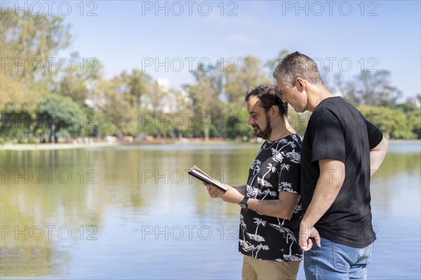 Couple of mature men reading in a lake