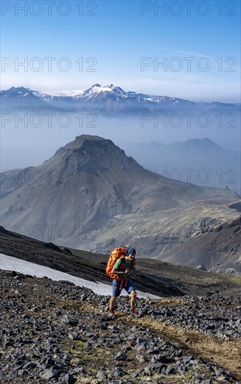 Hikers on trail through volcanic landscape