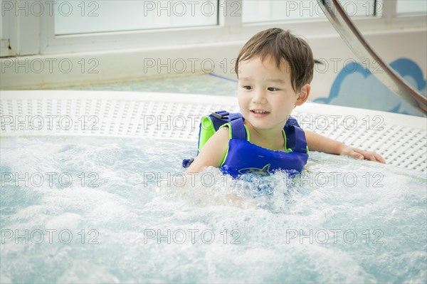 Adorable mixed-race boy having fun at the water park