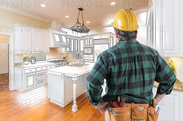 Male contractor with hard hat and tool belt looking at custom kitchen drawing photo combination on white