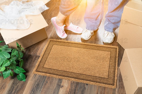 Man and woman standing near blank welcome mat