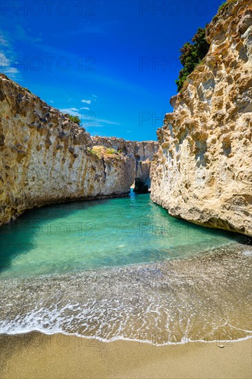 Papafragas hidden beach with crystal clear turquoise water and tunnel rock formations in Milos island