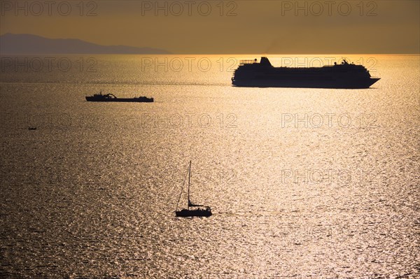 Cruise ship and yacht boat silhouettes in Aegean sea on sunset