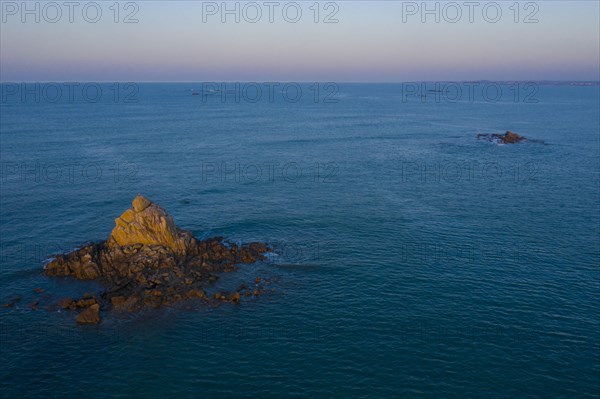 Aerial view of rock formations in the sea in front of the sandy beach Ker Emma shortly in front of sunset