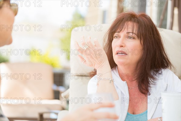 Two female friends enjoying conversation on the patio