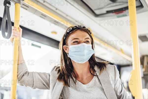 A young woman wearing protective mask commuting by the public bus