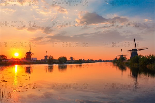 Netherlands rural landscape with windmills at famous tourist site Kinderdijk in Holland on sunset with dramatic sky