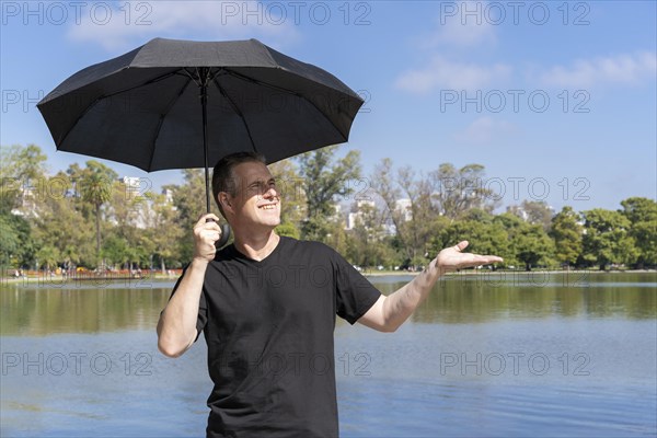 Caucasian man with umbrella on a sunny day