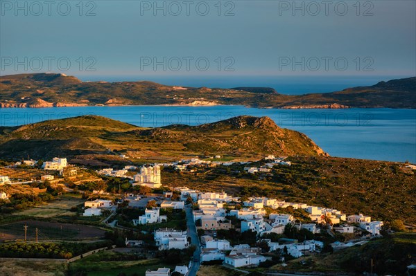 View of Plaka village on Milos island with traditional greek white houses on sunset. Plaka town