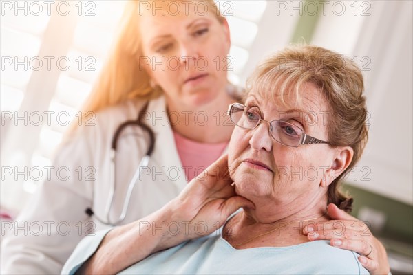 Melancholy senior adult woman being consoled by female doctor or nurse