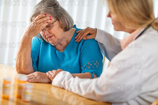 Female doctor consoling distraught senior adult woman