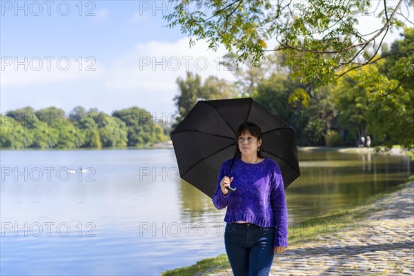 Latin woman with umbrella on a sunny day