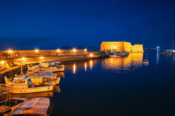 Venetian Fort castle in Heraklion and moored Greek fishing boats in port