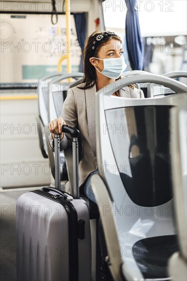 A young woman wearing protective mask commuting by the public bus