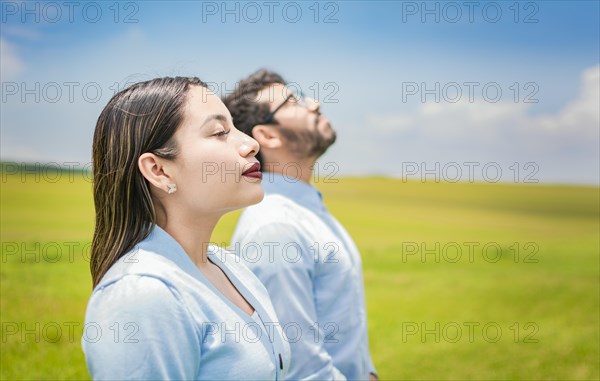 Young couple breathing fresh air in the field