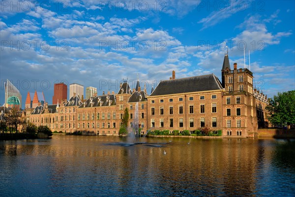 View of the Binnenhof House of Parliament and the Hofvijver lake with downtown skyscrapers in background. The Hague