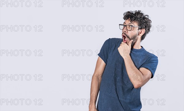 Amazed young man with hand near open mouth