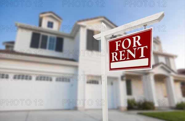 Red for rent real estate sign in front of beautiful house