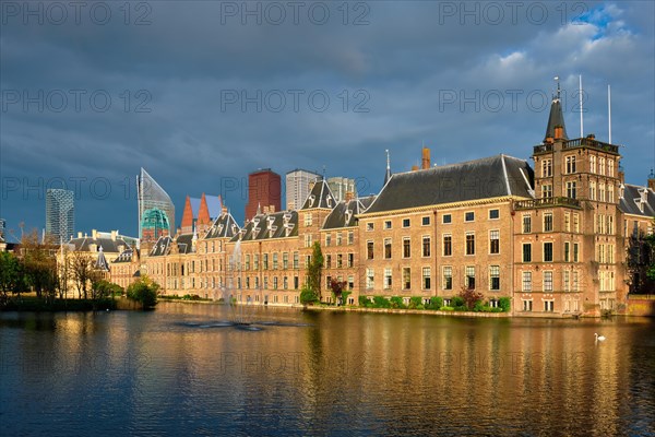 View of the Binnenhof House of Parliament and the Hofvijver lake with downtown skyscrapers in background