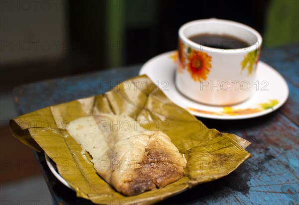 Stuffed tamale served on wooden table