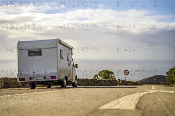 Small camper van parked on the side of the road in Arrabida Natural Park