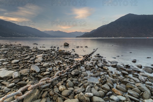 Rusty chain on gravel leads into the water