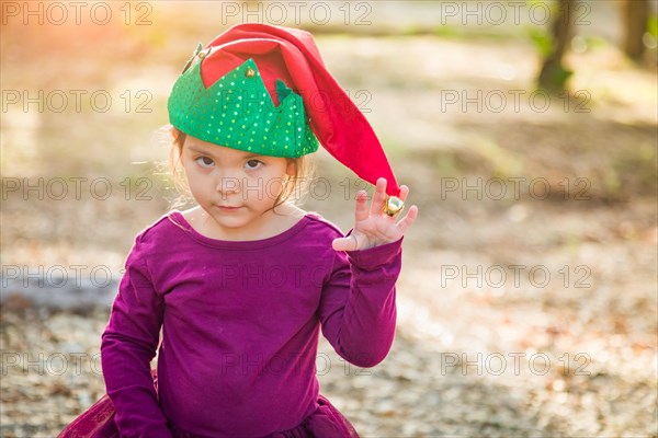 Cute mixed-race young baby girl having fun wearing christmas hat outdoors