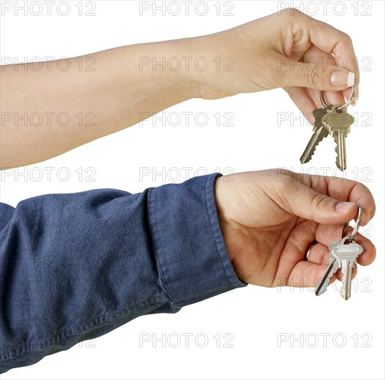 Man and woman handing over house keys on a white background with clipping path