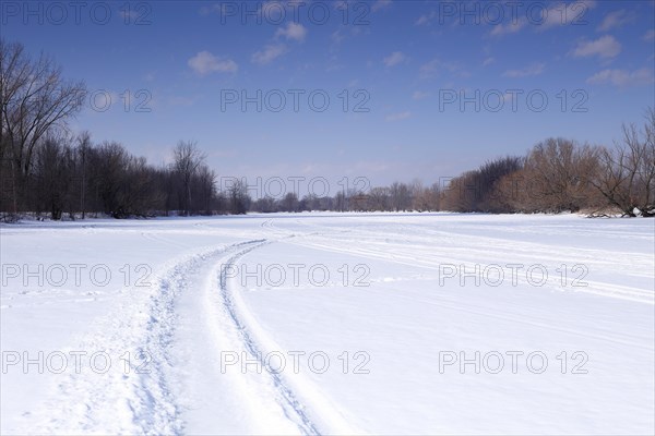 Snow vehicle tracks on a frozen river surface