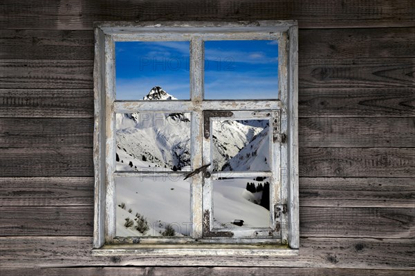 View through a rustic wooden window of the Lechtal Alps