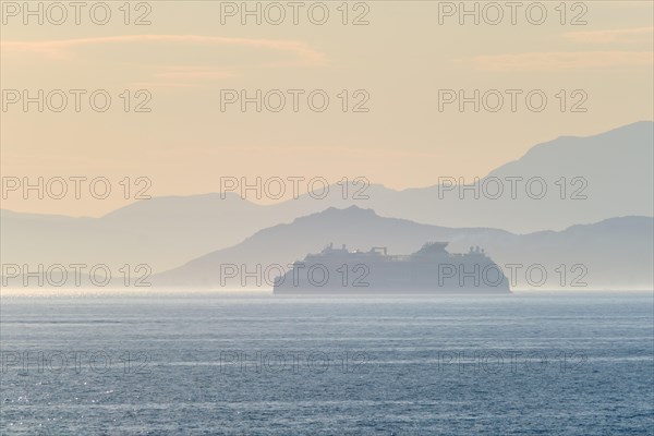 Cruise liner ship silhouette in haze in Mediterranea sea