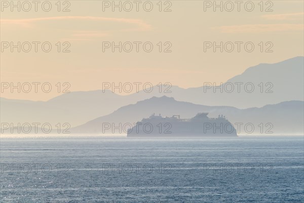 Cruise liner ship silhouette in haze in Mediterranea sea