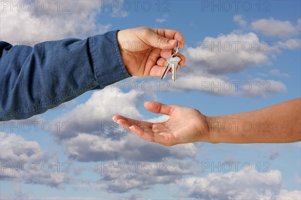 Handing overe the keys over a beautiful sky