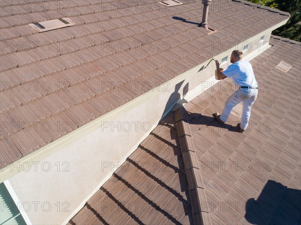 Professional painter using A brush to paint house facade