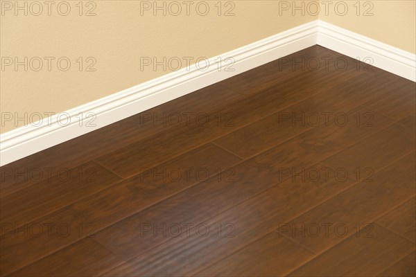 Beautiful newly installed brown laminate flooring and baseboards in home