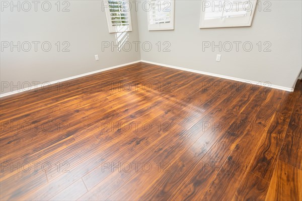 Newly installed brown laminate flooring and baseboards in home