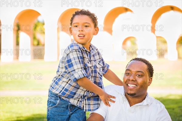 Happy african american father and mixed-race son playing at the park