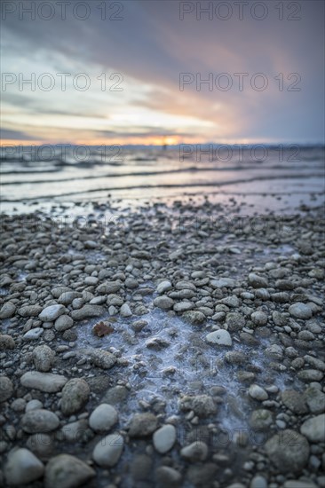 Sunrise on a wintry lake in bad weather