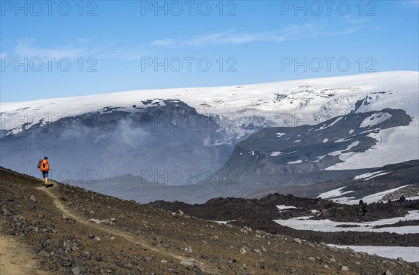 Hikers on trail through volcanic landscape