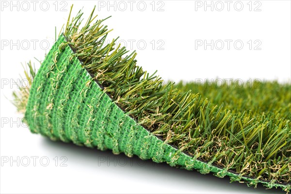 Flipped up section of artificial turf grass on white background