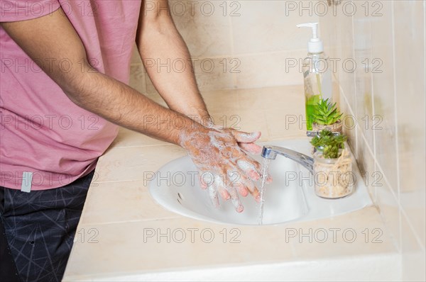 Close up of a man washing their hands with soap
