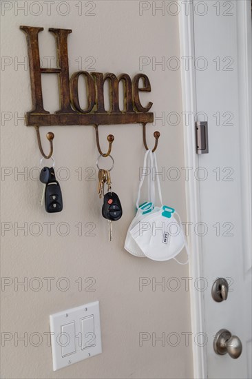 Home key hanger rack next to door with keys and medical face mask during coronavirus pandemic