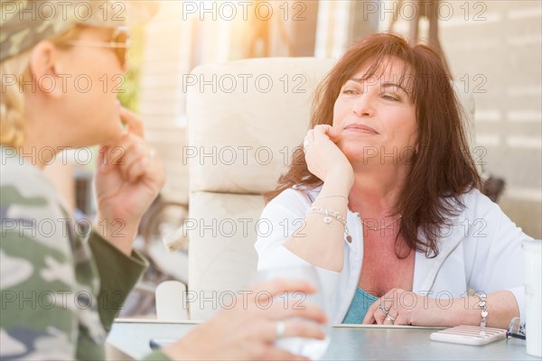 Two female friends enjoying conversation on the patio