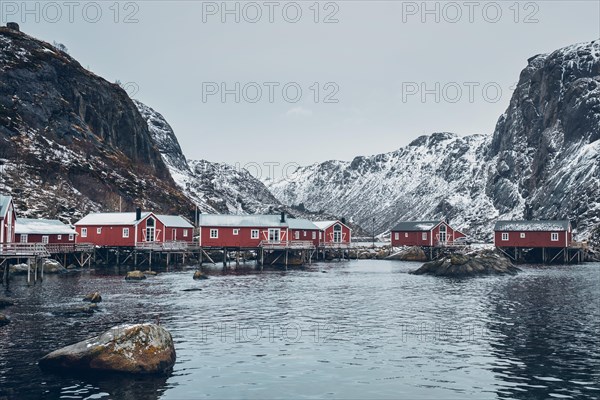 Nusfjord authentic traditional fishing village with traditional red rorbu houses in winter in Norwegian fjord. Lofoten islands