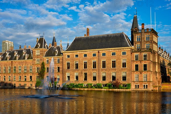 View of the Binnenhof House of Parliament and the Hofvijver lake with downtown skyscrapers in background. The Hague